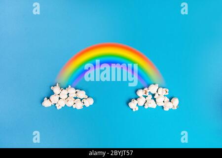 Popcorn clouds on a blue background with the colorful rainbow Stock Photo