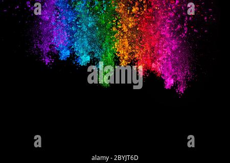 Falling colored powder. Rainbow of purple, blue, green, yellow, red and pink dust over black background with copy space for text Stock Photo