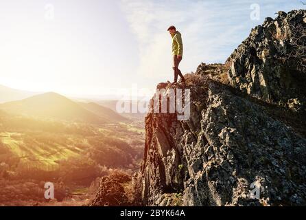 Back view of man wanderlust tours excited with natural environment and scenery during during colorful sunset. Hiker exploring nature in wild trip Stock Photo
