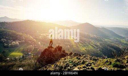 Back view of man wanderlust tours excited with natural environment and scenery during during colorful sunset. Hiker exploring nature in wild trip Stock Photo