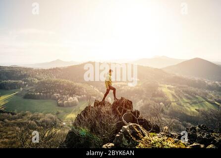 Back view of man wanderlust tours excited with natural environment and scenery during during colorful sunset. Hiker exploring nature in wild trip Stock Photo