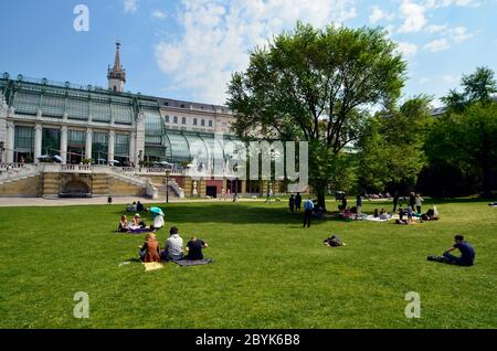 Vienna, Austria - April 24th 2011: unidentified people take a picnic in the grass of the public Burggarten with view to the new renovated palm house a Stock Photo