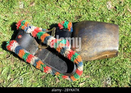 BAD HINDELANG, BAVARIA, GERMANY - SEPTEMBER 10 2011: Huge colorful cowbell lying in the grass at the traditional annual Almabtrieb, Viehscheid in Stock Photo