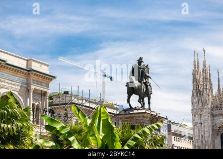 Milan. Italy - May 21, 2019: Vittorio Emanuele II Statue in Milan on Piazza Duomo. Palm Trees on Foreground. Stock Photo