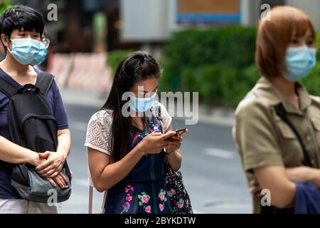 Passengers with face mask with social distancing at bus stop during Covid pandemic, Bangkok, Thailand Stock Photo