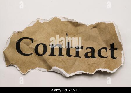 Cancelled agreement concept: Close up of isolated crumpled piece of scrap paper with word contract, white background Stock Photo