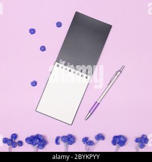 Open blank notebook and pen with flowers on table. Top view, flat lay Stock Photo