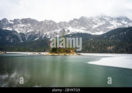 Beautiful winter day at the Eibsee near grainau at the mountain zugspitze, reflection of island Braxeninsel in the winter Stock Photo