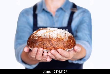 A woman holds in her hands an appetizing, crunchy, home-made rye sourdough bread Stock Photo