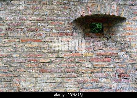 Background of a historic brick wall with a peephole on the side Stock Photo