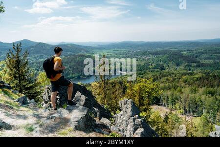 Hiker with backpack enjoying valley view from top of a mountain. Sport and active life concept. Adventure and travel in the mountain Stock Photo