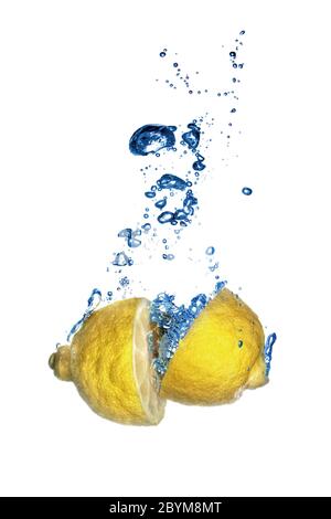 Fresh lemon dropped into water with bubbles isolated on white Stock Photo