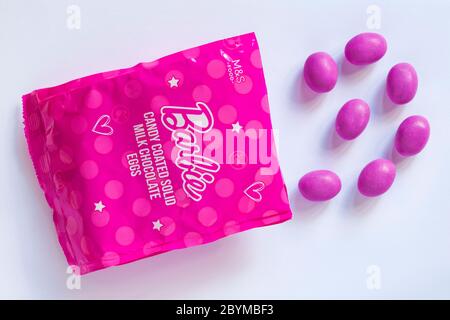 Packet of Barbie candy coated solid milk chocolate eggs opened with contents spilled spilt isolated on white background Stock Photo