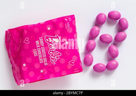 Packet of Barbie candy coated solid milk chocolate eggs opened with contents spilled spilt isolated on white background Stock Photo