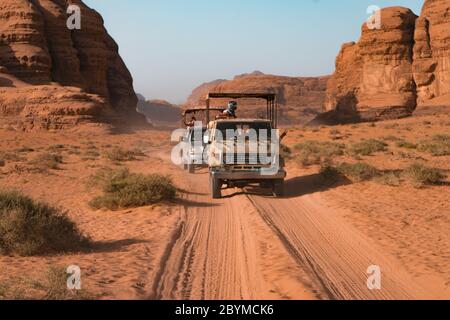 Driving on rough outback gravel red sand track. 4x4 off road land vehicle taking tourists on desert dune bashing safari. Wadi Rum desert in Jordan Stock Photo