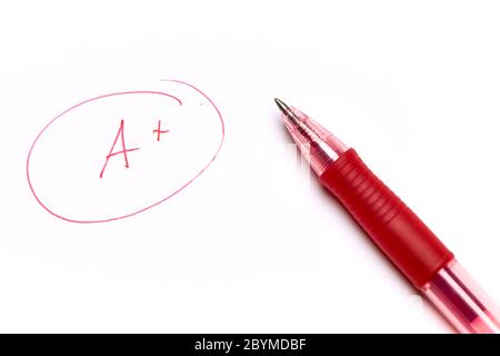 One note too many, written in red, on exam paper with the pen on top. Concept of education, success Stock Photo