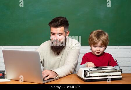 Elementary school teacher and student in classroom. Teacher helping pupils studying on desks in classroom. Concept of education and teaching. Little s Stock Photo