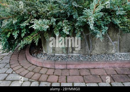 Decorative small pebbles and a paving stones in the garden. Garden hobby Stock Photo