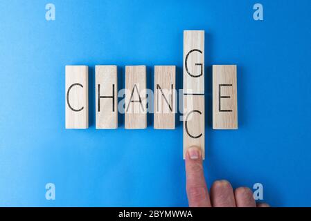 top view of hand of person changing the word CHANGE into CHANCE on wooden blocks Stock Photo