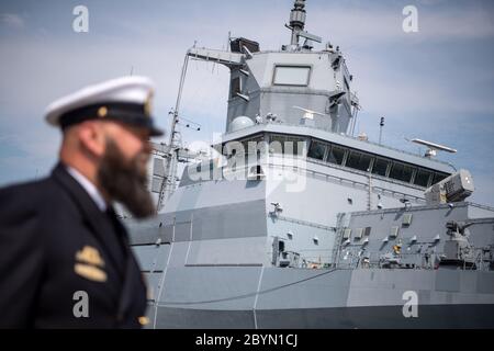 Wilhelmshaven, Germany. 10th June, 2020. A navy soldier stands in front of the 'Nordrhein-Westfalen'. The Navy has put the second of four new F 125 class frigates into service. The 'Nordrhein- Westfalen' is the sister ship of the 'Baden-Wuerttemberg', which joined the fleet a year ago. The ship was built for long-term maritime stabilization operations. Credit: Sina Schuldt/dpa pool/dpa/Alamy Live News Stock Photo