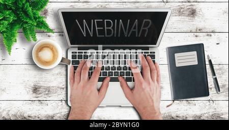 online education and e-learning concept, top view of person using laptop computer on wooden table to participate in webinar Stock Photo