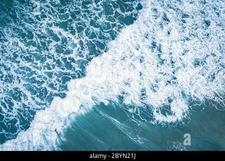 Aerial top view of white foam on the surface of the blue sea. Stock Photo