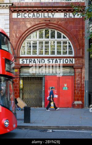 LONDON - SEPTEMBER 23, 2019: Entrance to the disused Aldwych Tube Station on The Strand with a London Double Decker Bus about to pass Stock Photo