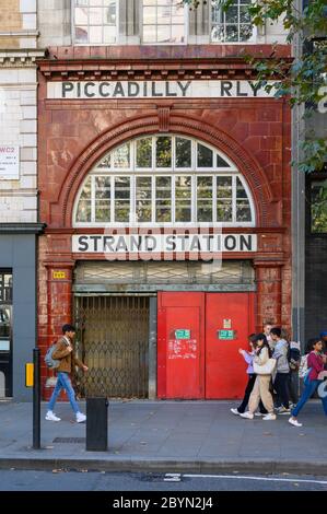 LONDON - SEPTEMBER 23, 2019: Students passing in front of the Entrance to the disused London Underground Aldwych Tube Station on The Strand Stock Photo