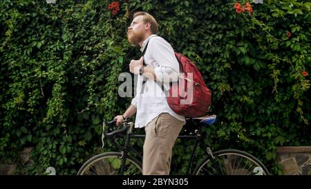 Portrait of bearded hipster man walking with vintage bicycle at park Stock Photo
