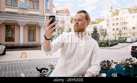 Portrait of stylish bearded hipster man using smartphone on city street Stock Photo
