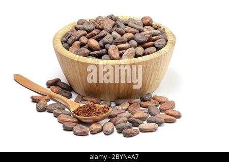 Raw cocoa beans in wooden bowl and spoon with cocoa powder. Chocolate ingredients isolated on white background. Stock Photo