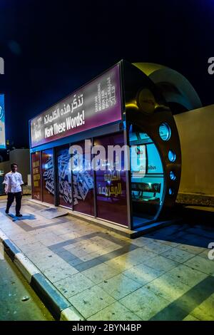 An air conditioned bus stop in Dubai with a tourist reflection in the glass. Stock Photo