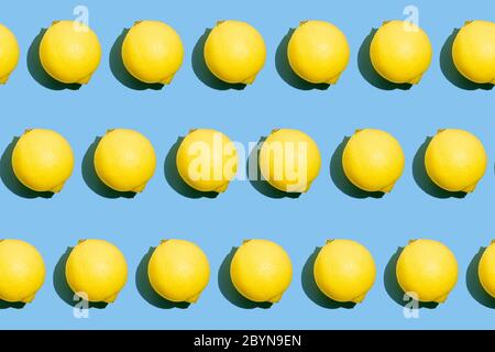 Repeating seamless photo pattern of fresh whole yellow lemons on blue background. Food texture. Stock Photo