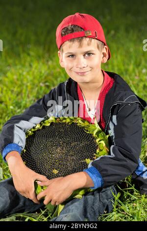 Young happy boy hold sunflower in a garden Stock Photo