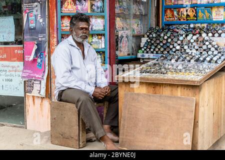 Chennai, Tamil Nadu, India - August 2018: An Indian street vendor selling wristwatched and music CDs in his pavement shop. Stock Photo