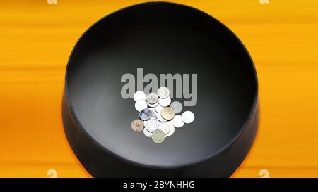 coins in monk's bowl, thai temple Stock Photo