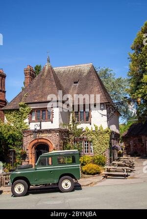 Green Land Rover Defender outside the old English Inn pub of George and Dragon at Great Budworth Cheshire England UK