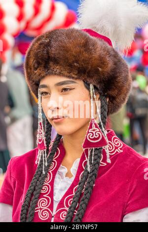 A Kyrgyz woman in traditional traditional costume and a man bring three ...