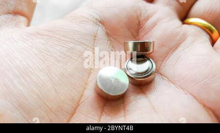 button cell battery on hand Stock Photo