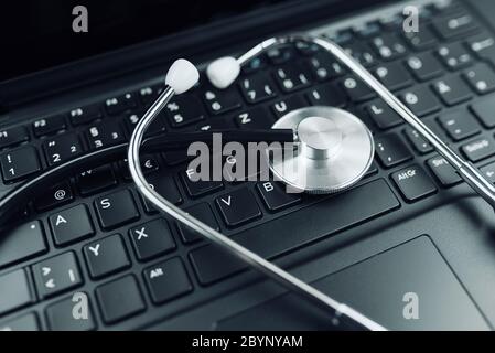 close-up high angle view of stethoscope on laptop computer keyboard Stock Photo