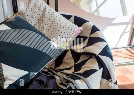 linen pillows with a geometric pattern lie on a plaid Stock Photo