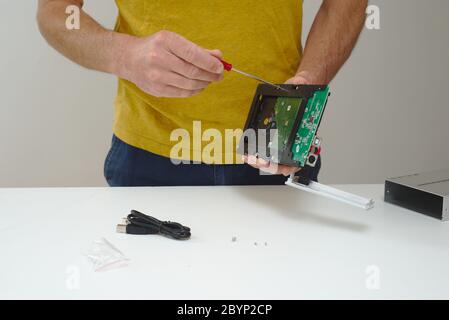 IT Technician fitting hard disk drive into external enclosure Stock Photo