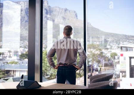 Caucasian business man standing in front of windows Stock Photo