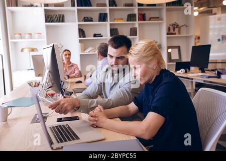 Caucasian businesspeople working together in workspace Stock Photo