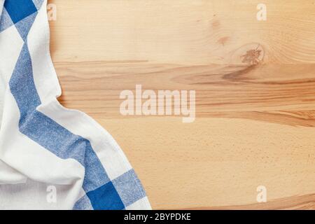 Top view on a wooden table with a linen kitchen towel or textile napkin. a tablecloth on a countertop made of old wood. Stock Photo