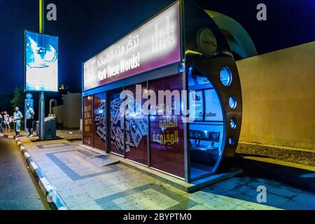 An air conditioned bus stop in Dubai with a tourist reflection in the glass. Stock Photo