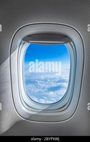 View through airplane window, sky over the clouds Stock Photo