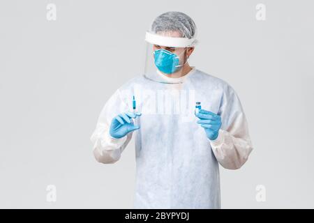 Covid-19, pandemic, healthcare workers fighting virus outbreak. Doctor carefully holding syringe with covid 19 vaccine, treating patient during Stock Photo