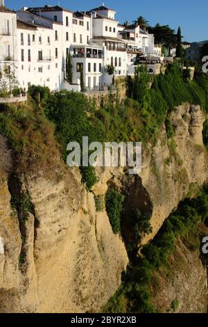 View of cliff top houses in evening sunshine in Ronda Andalusia Spain Stock Photo