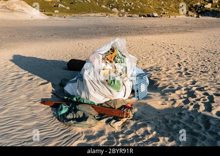 Plastic bottles and other trash on sea beach. During a vibrant summer sunset. Garbage and wastes on the beach of Atlantic ocean, Lofoten, Norway Stock Photo